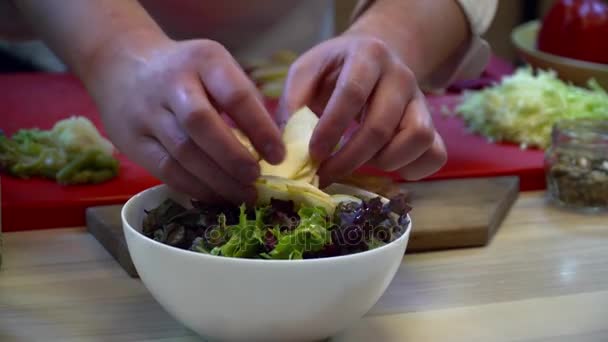 Шеф-повар делает салат с овощами на кухне крупным планом — стоковое видео