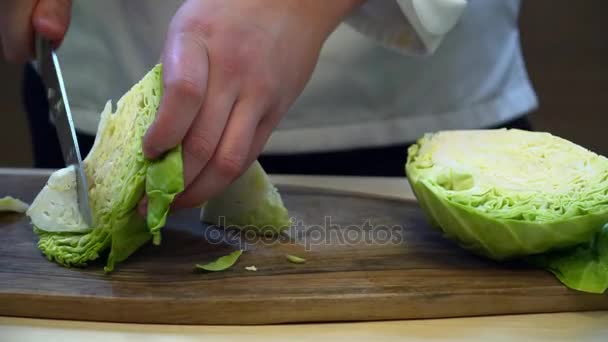 Close-up van chef-kok snijden kool met het mes — Stockvideo