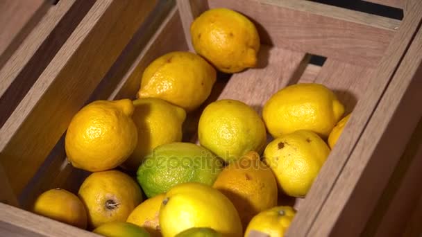 Свежие желтые лимоны в деревянной коробке — стоковое видео