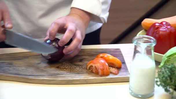 Koch schneidet Tomaten und Zwiebeln auf dem Holzbrett — Stockvideo