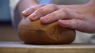 Şef closeup kesme ekmek hamburger için eller