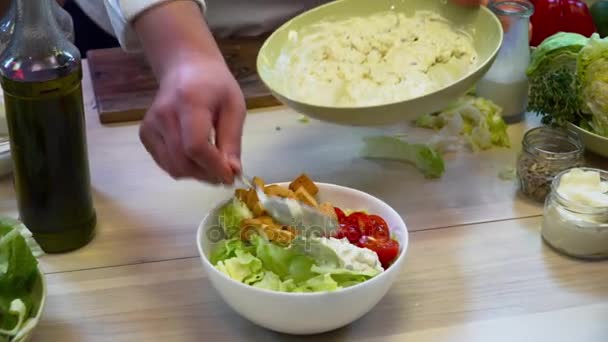 Chef haciendo ensalada con verduras y salsa en la mesa de madera — Vídeo de stock