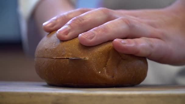 Крупним планом кухарські руки ріжуть хліб для гамбургера — стокове відео
