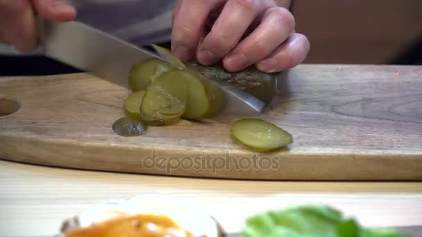 Vértes chef darabolás savanyúságok az a hamburger — Stock videók