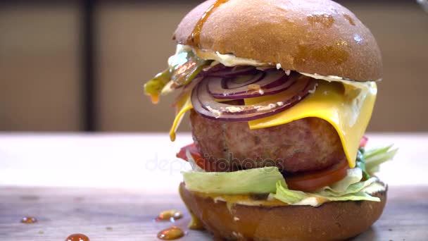 Smakelijke hamburger met grote vlees op tafel — Stockvideo