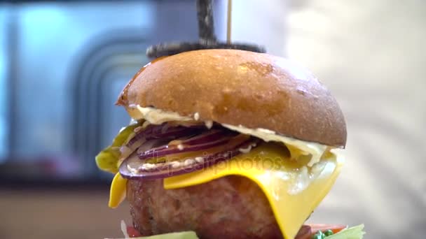 Смачний гамбургер з великим м'ясом на дерев'яному столі — стокове відео