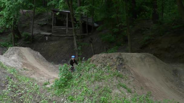 Persoană sărind pe bicicletă în pădure — Videoclip de stoc