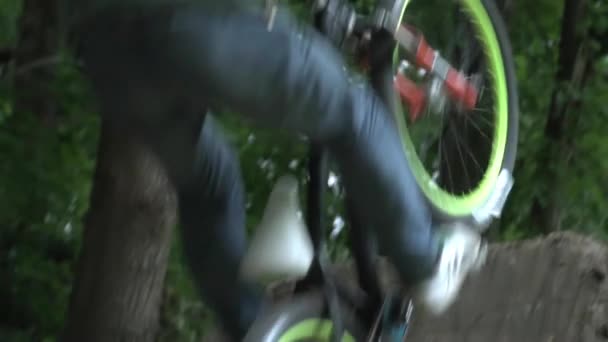 Mann mit Helm springt auf modernem Fahrrad im Wald in Zeitlupe — Stockvideo