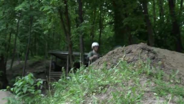 Homme sautant sur le vélo moderne dans la forêt au ralenti 