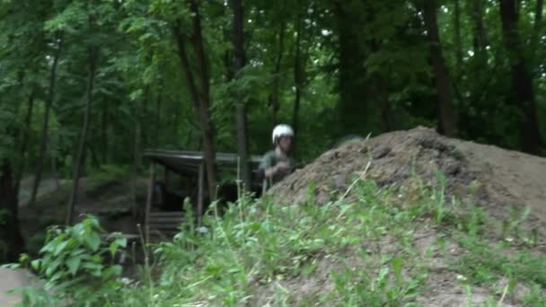 Hombre saltando en bicicleta moderna en el bosque cámara lenta — Vídeos de Stock