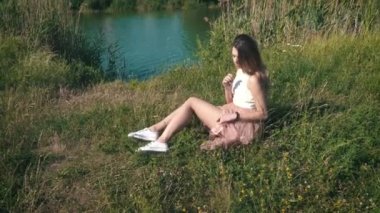 Genç kadın rahatlatıcı nehir kıyısında