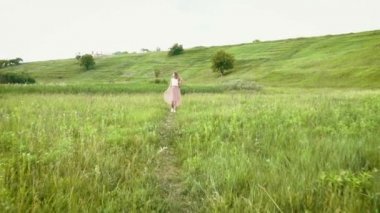 Genç kadın yaz çayır yavaş hareket üzerinde çalışan