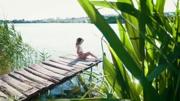 Jonge vrouw ontspannen in de buurt van het meer — Stockvideo