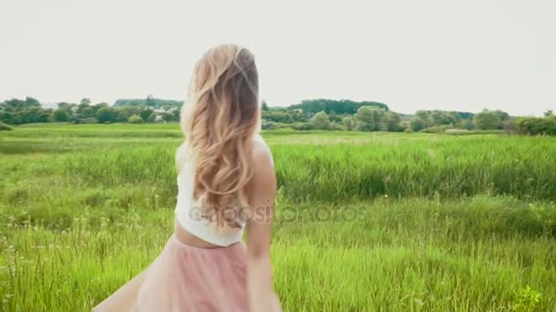 Jeune femme balançant ses cheveux abondants sur la prairie d'été ralenti — Video