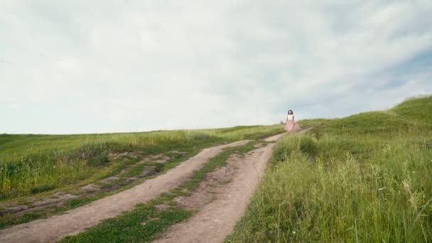 Young beautiful woman running down the country road — Stock Video