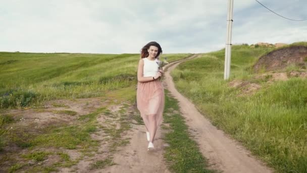 Young beautiful woman running down the country road slow motion — Stock Video