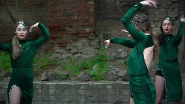 Unga kvinnor i gröna dräkter dansar nära trädet — Stockvideo