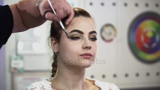Estilista masculino fazendo maquiagem para uma noiva no estúdio close-up — Vídeo de Stock