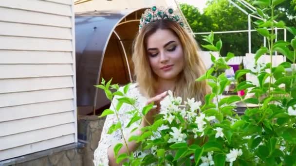 Giovane sposa toccare i fiori sul cespuglio durante l'estate — Video Stock