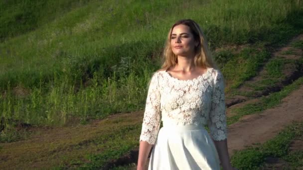 Belle femme en robe blanche marchant sur le chemin gros plan — Video