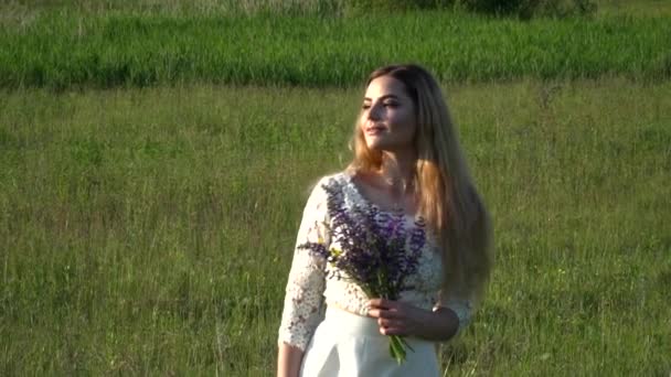 Mooie jonge vrouw die het verzamelen van bloemen op de weide slow motion — Stockvideo
