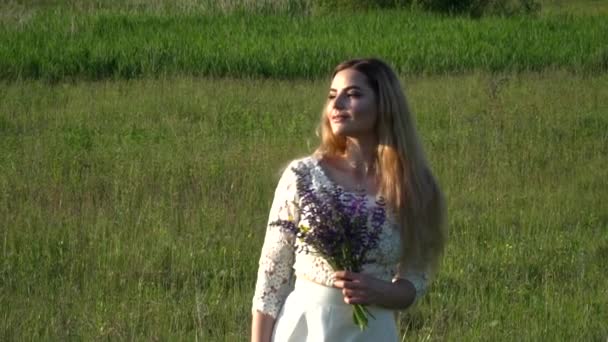 Bella giovane donna che raccoglie fiori sul prato rallentatore — Video Stock