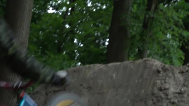 Gros plan de l'homme dans le casque sautant à vélo dans la forêt ralenti gros plan 