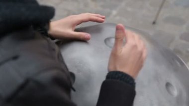 Genç sokak sanatçı sokakta gerçekleştirme. Performans Handpan veya geleneksel etnik davul müzik aleti elinde asmak ile yakın çekim