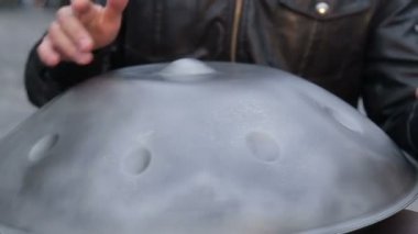 Genç sokak sanatçı sokakta gerçekleştirme. Performans Handpan veya geleneksel etnik davul müzik aleti elinde asmak ile yakın çekim
