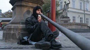 Bir sokak müzisyen didgeridoo, Kuzey Avustralya yerli Avustralyalılar tarafından geliştirilen bir üflemeli çalgı çalmaya.