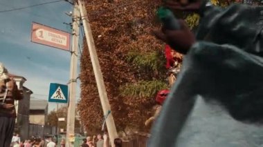 Sokakta tatil, yerel geçit töreni, farklı kostümler giyen insanlar var.