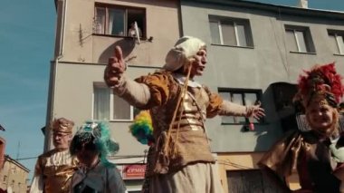 Sokakta tatil, yerel geçit töreni, farklı kostümler giyen insanlar var.