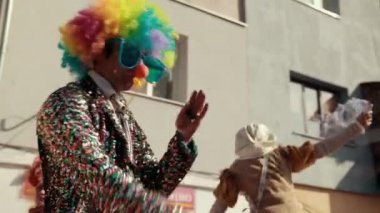 Sokakta tatil, yerel geçit töreni, farklı kostümler giyen insanlar var.