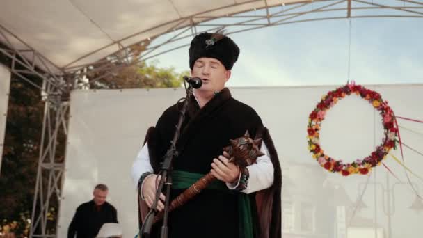 Homem de roupas tradicionais ucranianas em pé no palco — Vídeo de Stock