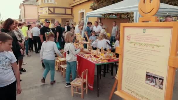Kleines Mädchen spielt auf Jahrmarkt Holzspielzeug und entscheidet, was es zu kaufen gibt — Stockvideo