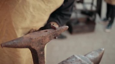 Smith, ateşteki sıcak metalden ayrıntı oluşturuyor. Yakın plan. Antik gelenekler.