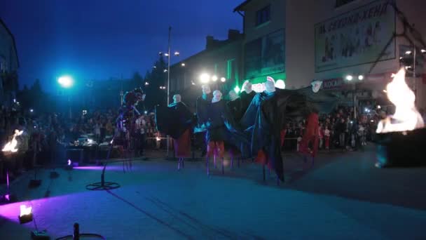 Espectáculo de fuego fuera, en la noche para la multitud de personas, caminantes stilt realizar . — Vídeos de Stock
