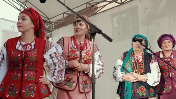 Females perform folk play on decorated stage with microphones outside. — Stock Video