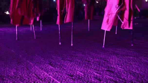 Rejtélyes gólyalábú járkálók az éjszakai tűzbemutatón. Szorító gólyalábak, középkori jelmezek — Stock videók
