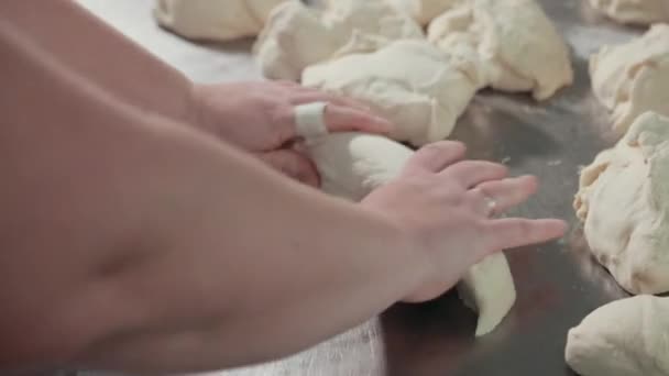 Le mani con fede nuziale, il cerotto stanno impastando, rotolando la pasta bianca elastica . — Video Stock