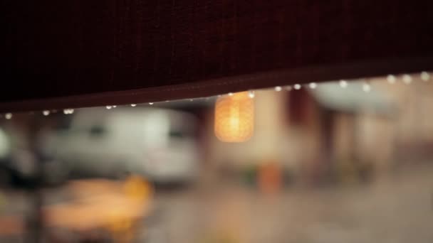 Raindrops dripping from edge of cafe canopy, they are falling down after rain. — Stock Video