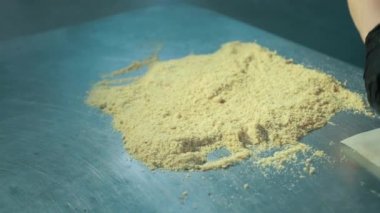 Kadın fırıncı üstünü kapatıyor, İsviçre böreğinin kenarları doğranmış fındıkla kaplı..