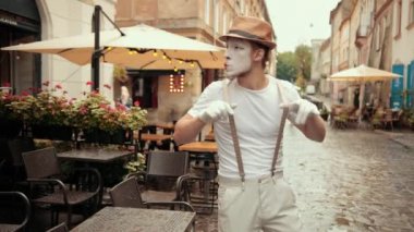 Yakışıklı pandomimci kendinden emin görünüyor, dışarıda bir şeyler arıyor, arıyor..