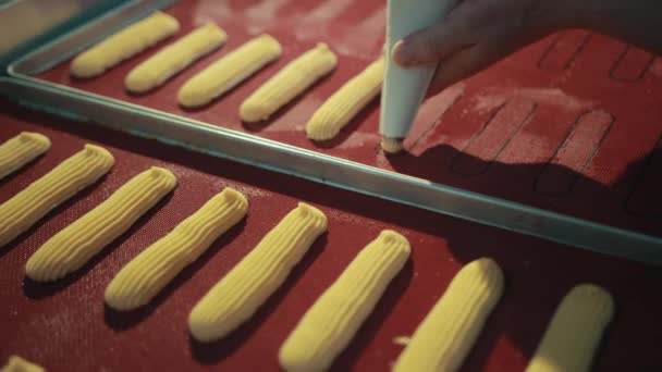 La mano del panadero está exprimiendo la masa en la bandeja del horno . — Vídeos de Stock