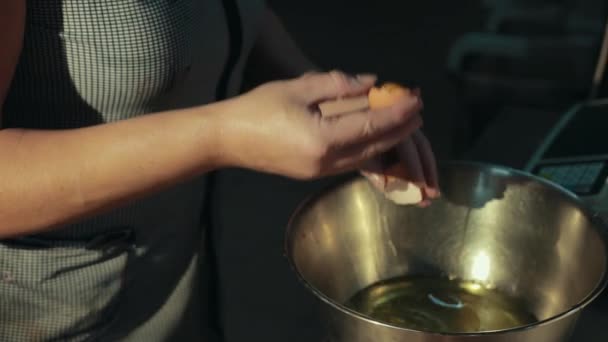 Woman separates whites from yolks fast, pouring egg whites into bowl. — Stock Video