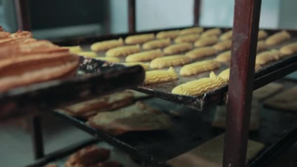 Estanterías con diferentes pasteles, mano en manopla pone bandeja por encima . — Vídeos de Stock