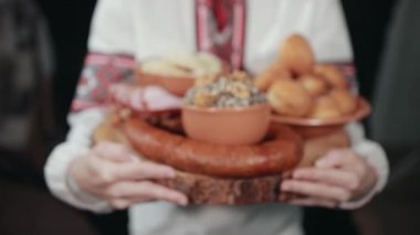 Geleneksel Ukrayna nakışlı elbiseli kız tahta tepsi taşıyor..