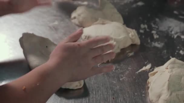 ステンレス製の作業台のキッチンで生地を扱う女性の手. — ストック動画