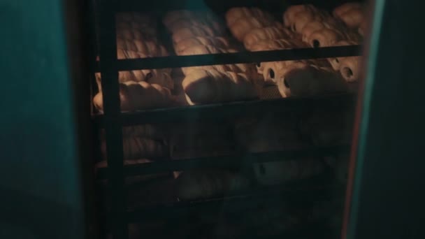 Croissants con agujeros en el interior yacía en bandeja en estanterías, hornear en horno . — Vídeos de Stock