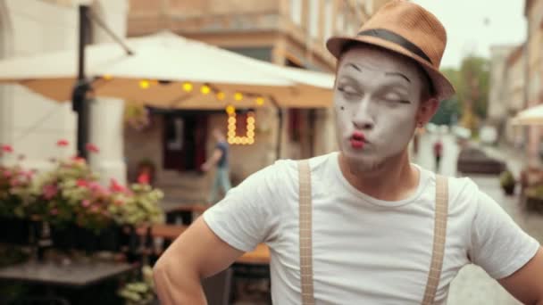 Jonge mimespeler ruziet met iemand op straat in de buurt van café, dan kalmeert, glimlacht. — Stockvideo